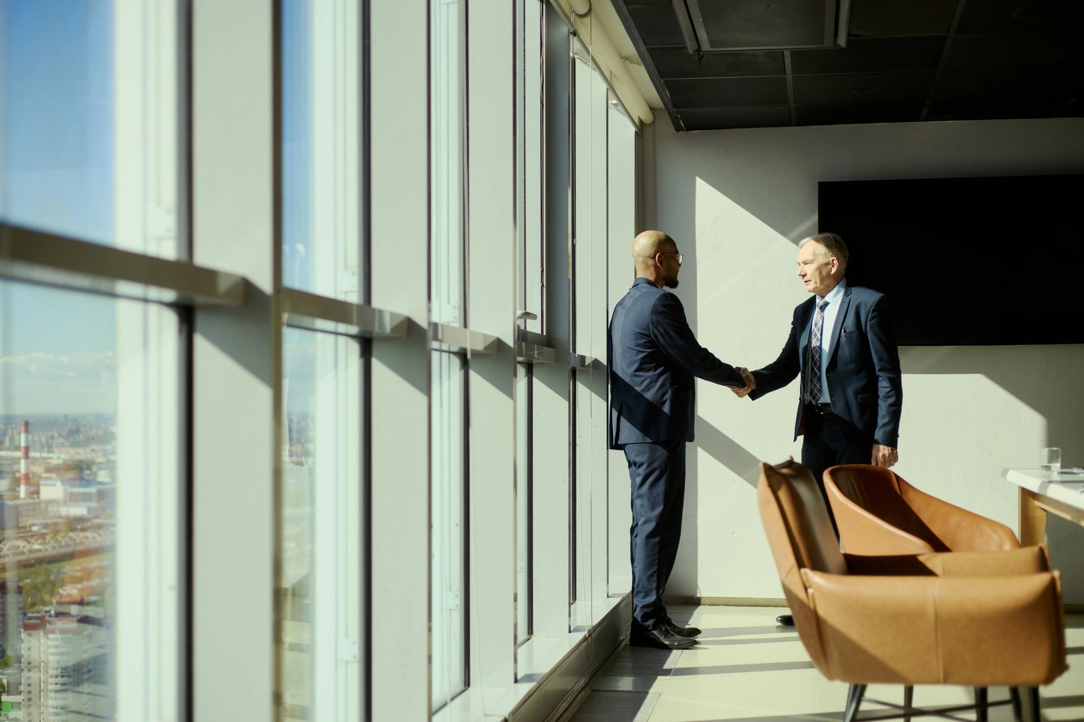Business leaders shaking hands after a successful advisory meeting
